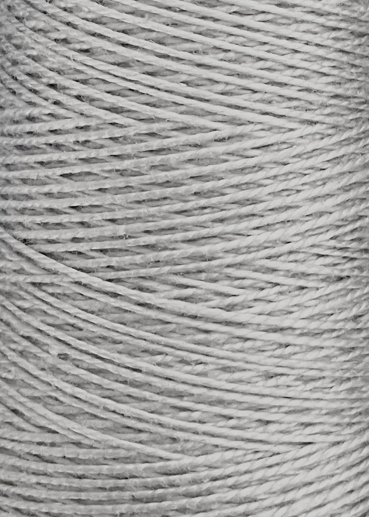 Close-up of tightly wound white string or twine on a spool, highlighting the detailed texture and overlapping fibers characteristic of premium weaving yarn such as Circulo's 5/2 Looma Circulo Mercerized Pearl Cotton Yarn | Large Cone.