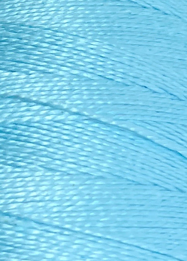 Close-up of tightly wound, shiny light blue thread on a large cone of Circulo 10/2 Looma Mercerized Pearl Cotton Yarn, highlighting the individual strands and smooth texture of this premium weaving yarn.