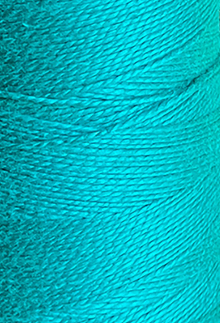 Close-up of a spool of bright turquoise Circulo 3/2 Looma Mercerized Pearl Cotton Yarn | Mini Cone, highlighting the texture of its tightly wound Oeko-Tex certified fibers.