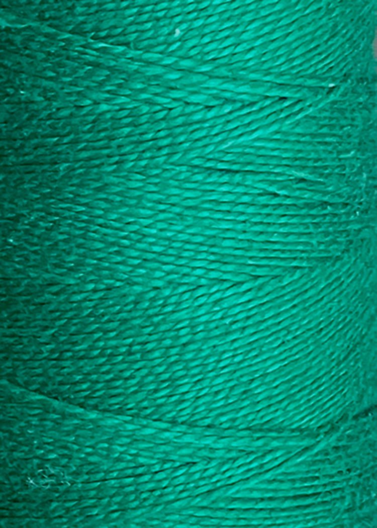 Close-up of a spool of vibrant green 5/2 Looma Circulo Mercerized Pearl Cotton Yarn (Mini Cone) by Circulo, highlighting the detailed texture and tightly wound fibers.