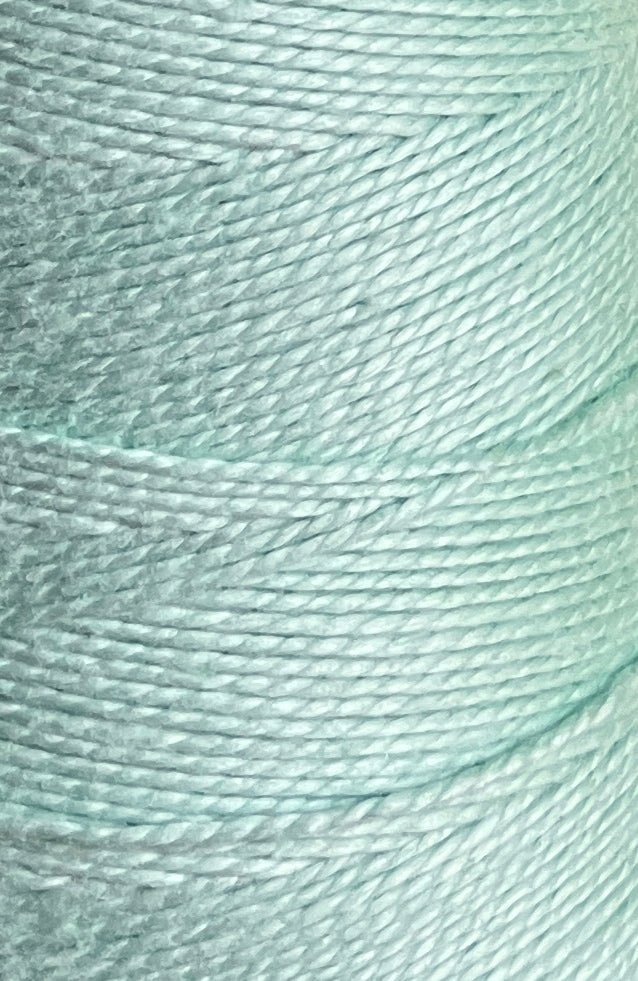 Close-up of a 3/2 Looma Circulo Mercerized Pearl Cotton Yarn Mini Cone in light blue by Circulo, highlighting the texture and tightly wound fibers.