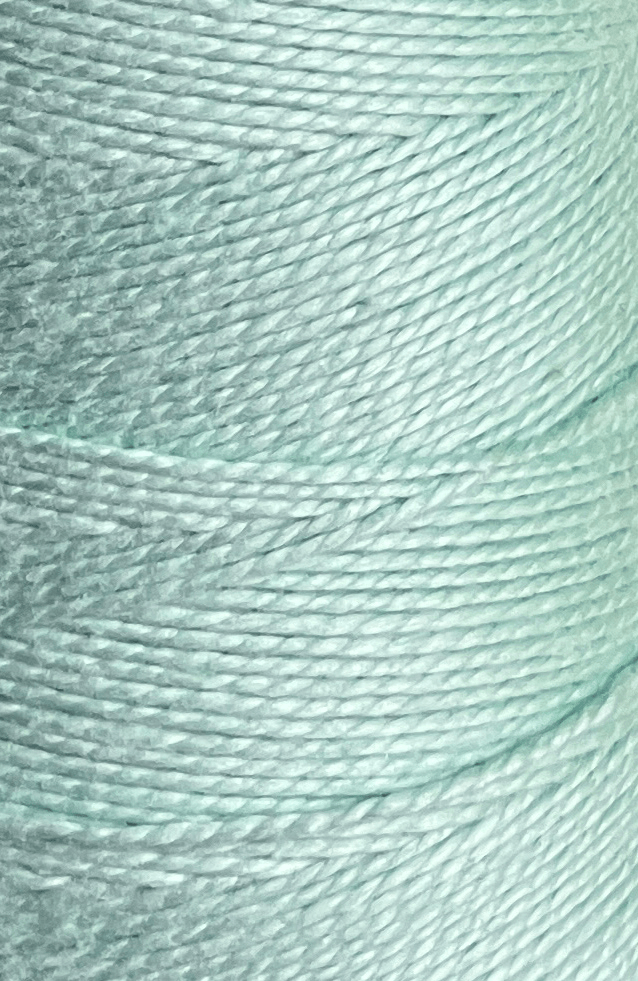 Close-up of tightly wound, pale blue Circulo 5/2 Looma Circulo Mercerized Pearl Cotton Yarn on a large cone, highlighting the texture and fine details of the mercerized fibers.