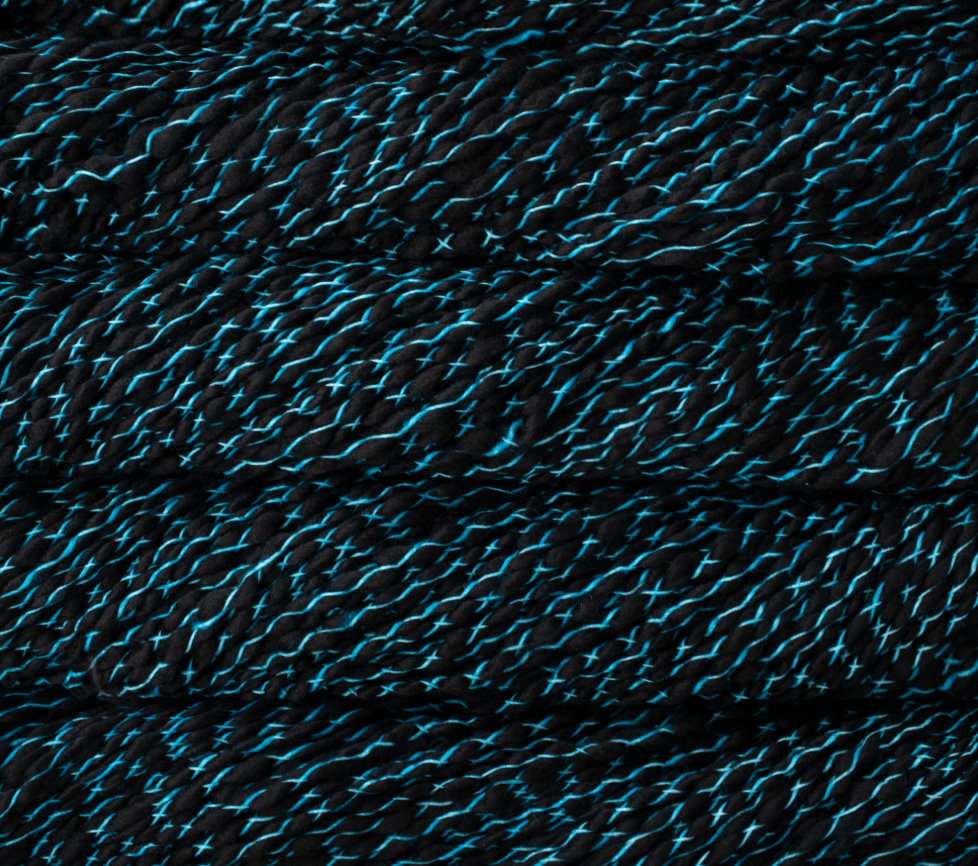 Close-up of Malabrigo Caracol super bulky, kettle-dyed merino wool yarn, featuring loosely plied, alternating black and bright blue strands.