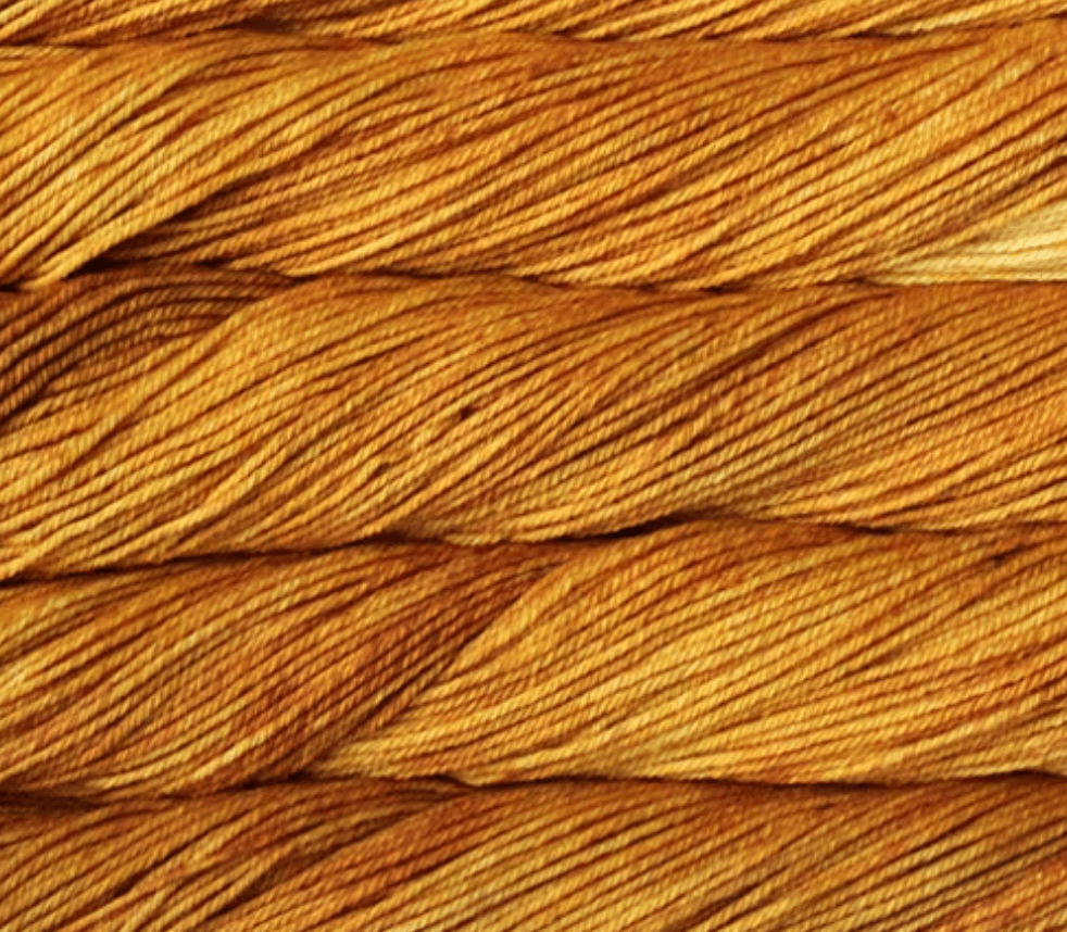 Close-up view of golden-yellow Malabrigo Rios kettle-dyed yarn twisted into skeins.