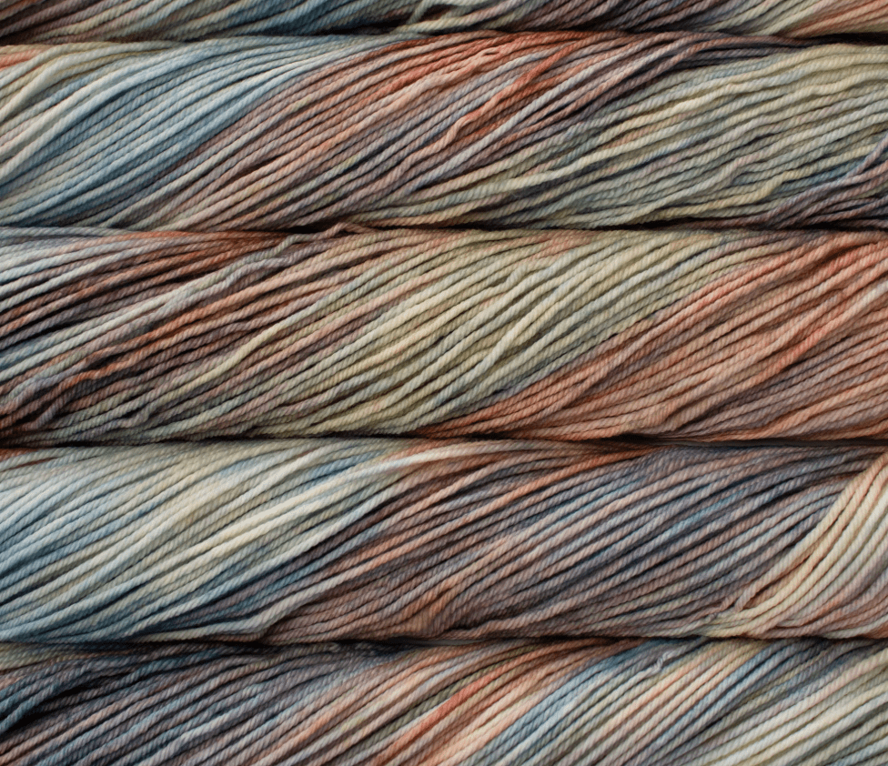Stacked skeins of Malabrigo Rios yarn in variegated, muted shades of blue, green, and copper.