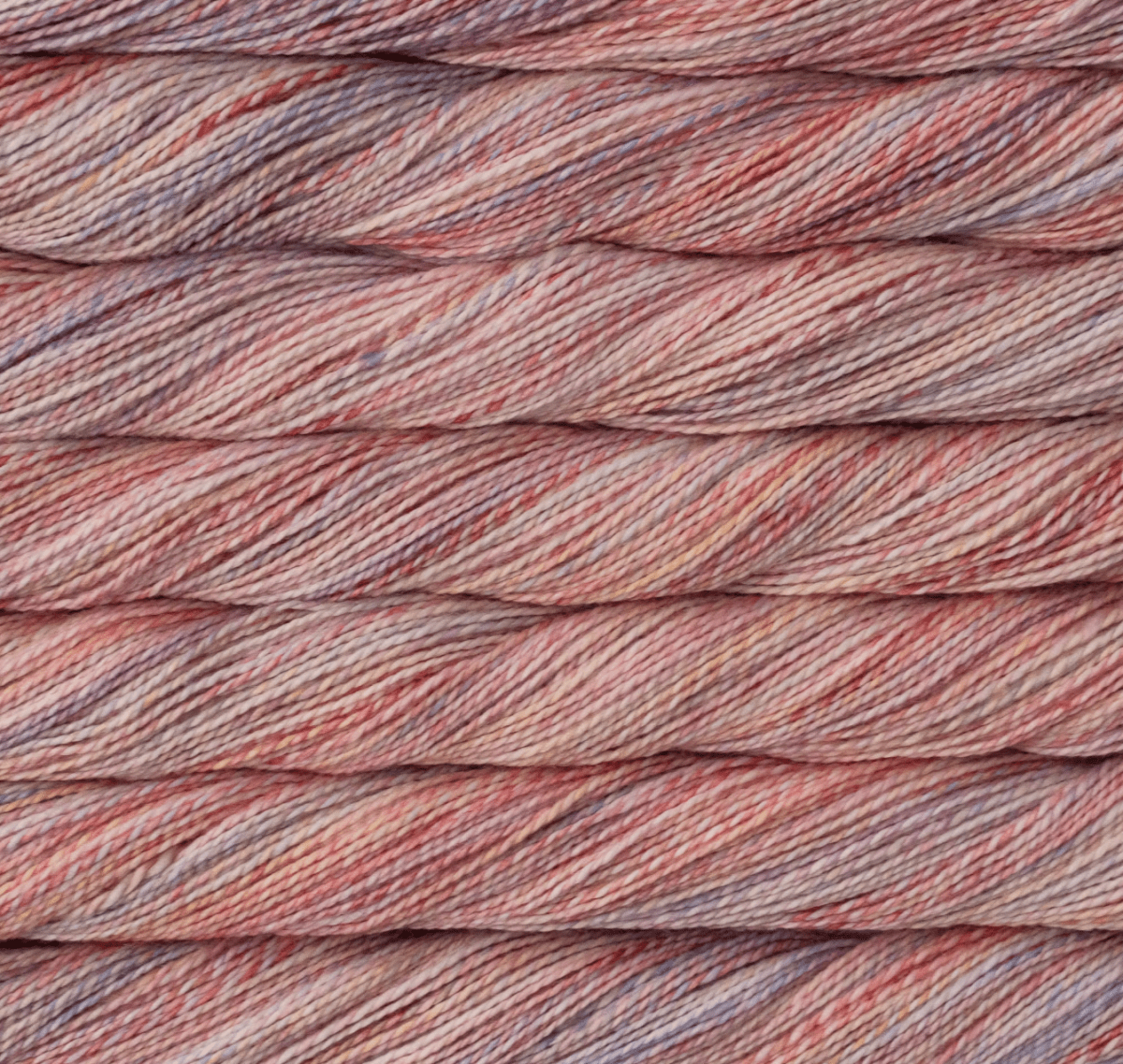 Close-up of a twisted skein of Malabrigo Torzal hand-dyed sport weight yarn in variegated shades of pink, peach, and soft purple.