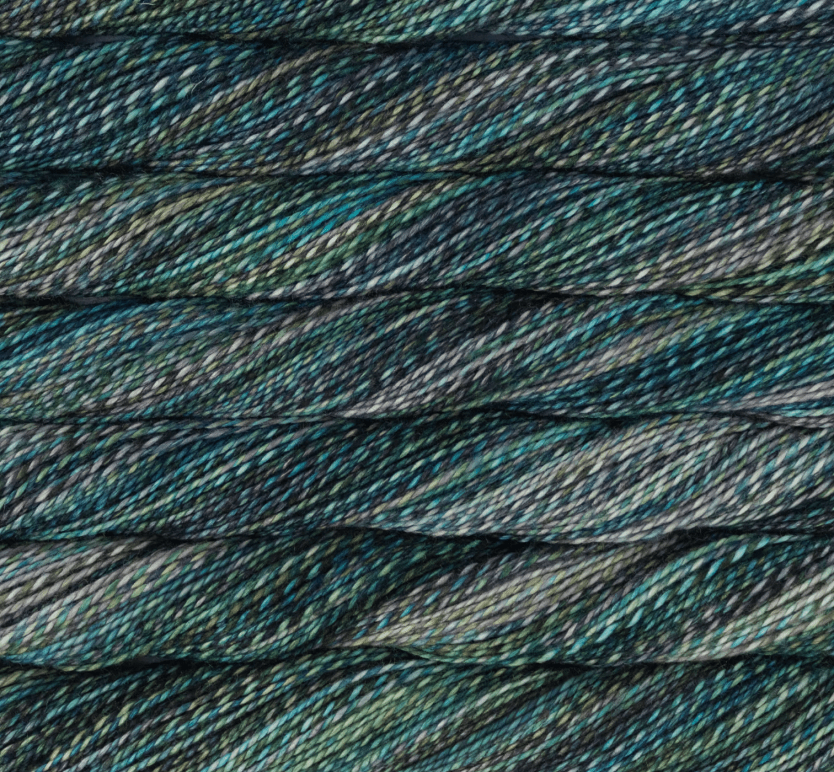 Close-up of a hand-dyed Malabrigo Torzal skein in sport weight, featuring a variegated blend of dark teal, forest green, grey, and black.