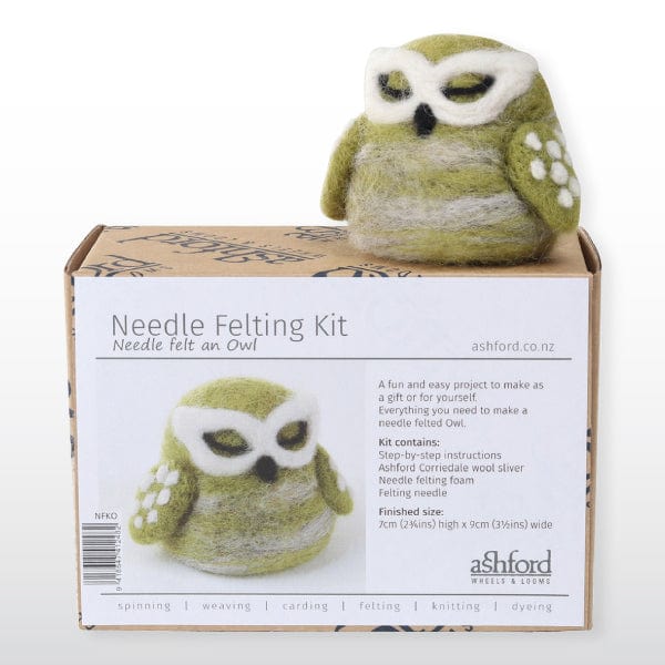 A green and white felted owl sits atop a box labeled “Ashford Needle Felting Kits” by Ashford Handicrafts Limited, showing the owl, kit details, and step-by-step beginner instructions—perfect for starting needle felting.
