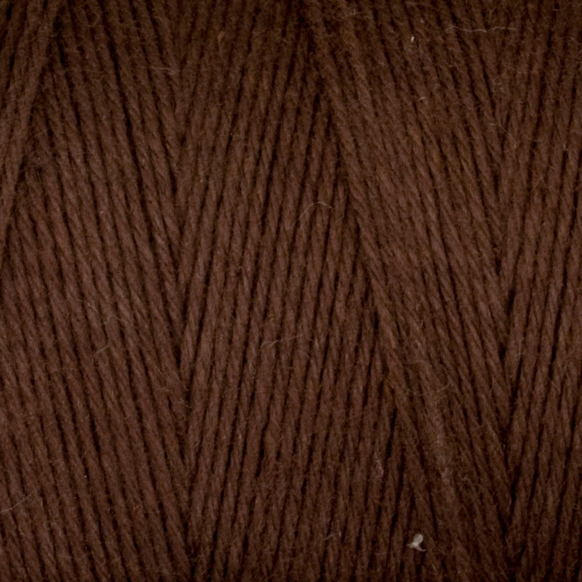Close-up of Great Northern Weaving Cotton Carpet Warp 8/4 shows tightly wound, soft 4-ply cotton fibers and diagonal patterns—ideal as colorfast yarn for rug making.