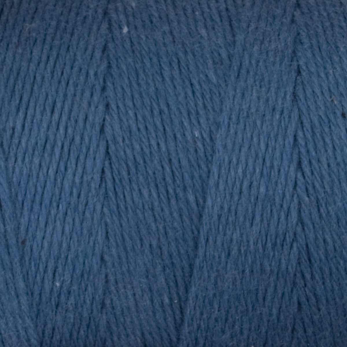 Close-up of Great Northern Weaving Cotton Carpet Warp 8/4 in blue, highlighting tightly wound 4-ply cotton strands and detailed parallel fiber alignment.
