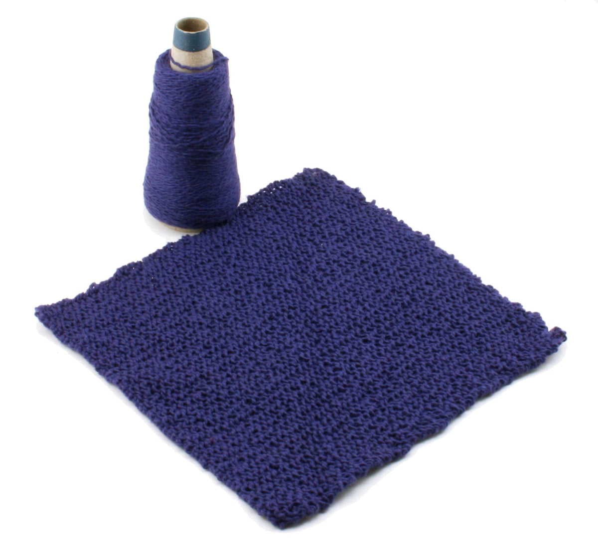A spool of Casco Bay Washcloths purple yarn by Halcyon Yarn stands next to a knitted purple swatch, both on a white background—ideal for making stylish washcloths.