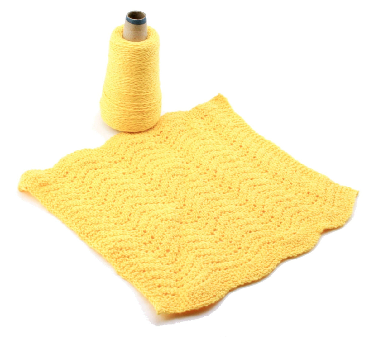 A cone of Halcyon Yarn's Casco Bay Washcloths yellow yarn sits beside a wavy, textured yellow washcloth on a white background.