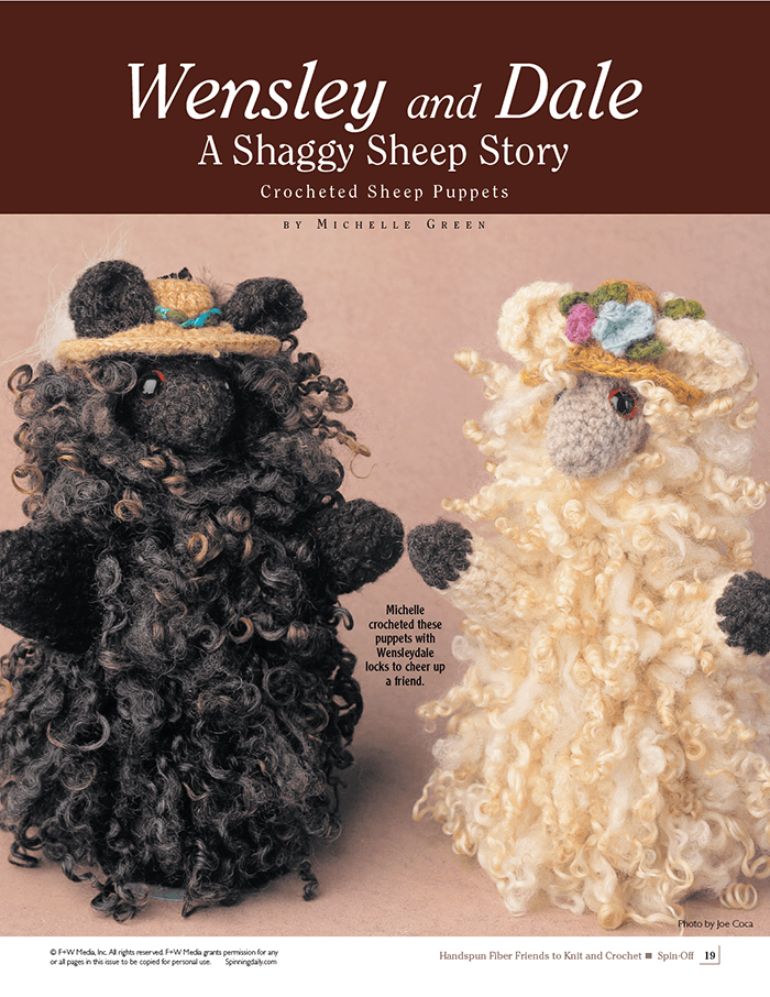Two adorable sheep puppets—one black, one cream, each with flowered straw hats—stand together. Find similar stash-busting knit and crochet patterns in "Spin-Off Presents: Handwoven, Fiber Friends to Knit and Crochet" by Long Thread Media.