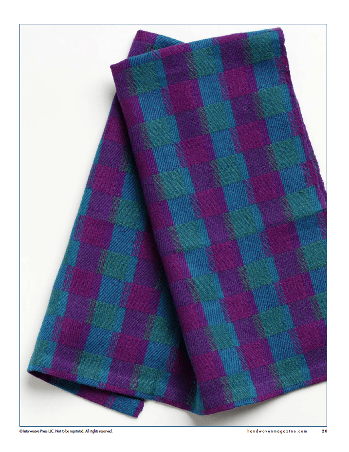 A folded piece of plaid fabric in blue, teal, and purple on a white background—ideal inspiration for winning towels featured in Long Thread Media’s "Winning Towels from Handwoven's 21st-Century Towel Contest" (eBook Printed Version).