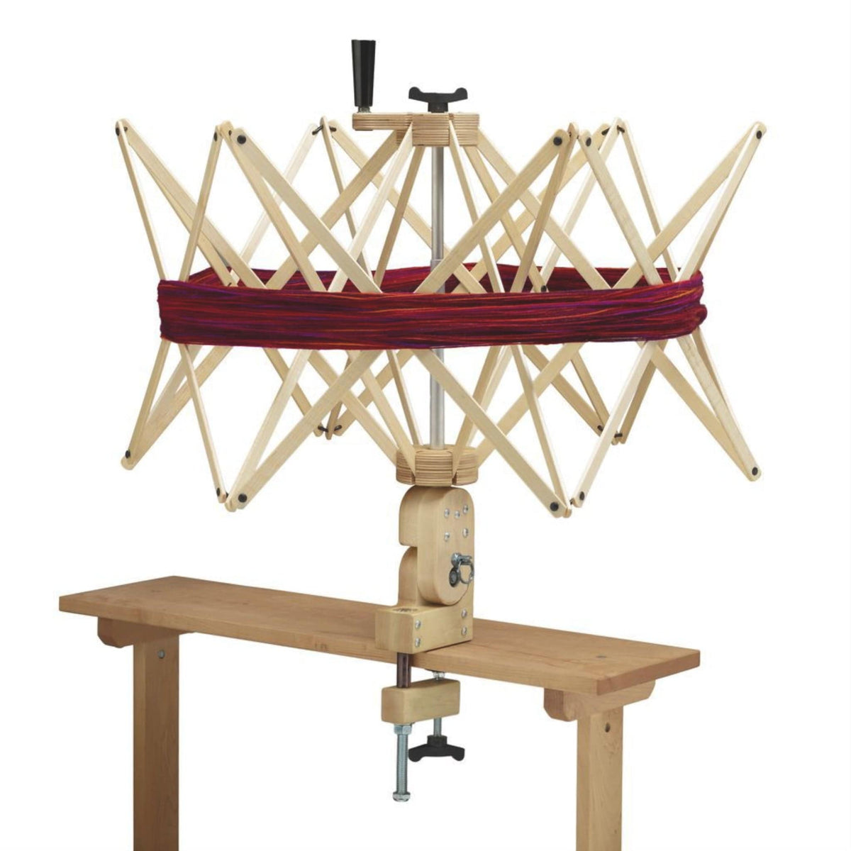 The Schacht Ultra Umbrella Swift by Schacht Spindle Co. is clamped to a table, its wooden arms extended to securely hold a loop of red yarn—perfect for winding yarn into balls. Temporarily out of stock with Schacht.
