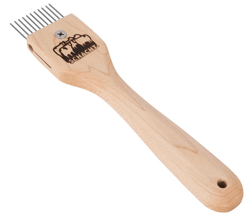 The Schacht Duet Tapestry Beater by Schacht Spindle Co. is a wooden-handled weaving tool with interchangeable metal combs featuring six metal prongs, and the handle is engraved with the Schacht company logo.