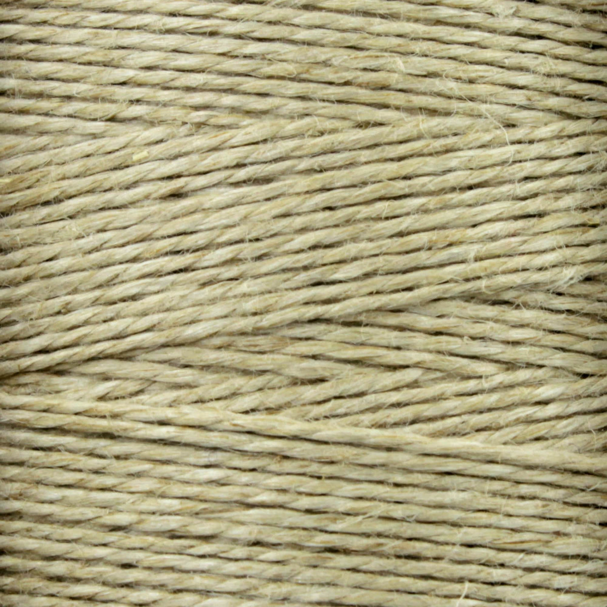 Close-up of tightly wound Soft Finish Linen Warps by Kingfisher Yarn & Fibre, highlighting the beige texture and visible fibers reminiscent of those used in tapestry weaving and Scandinavian rugs.