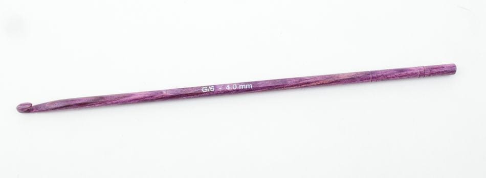 A Knit Pro (Knitters Pride) Dreamz Wooden Crochet Hook by Accessories Unlimited, size G/6 4.0 mm in purple, is shown lying horizontally on a white background.
