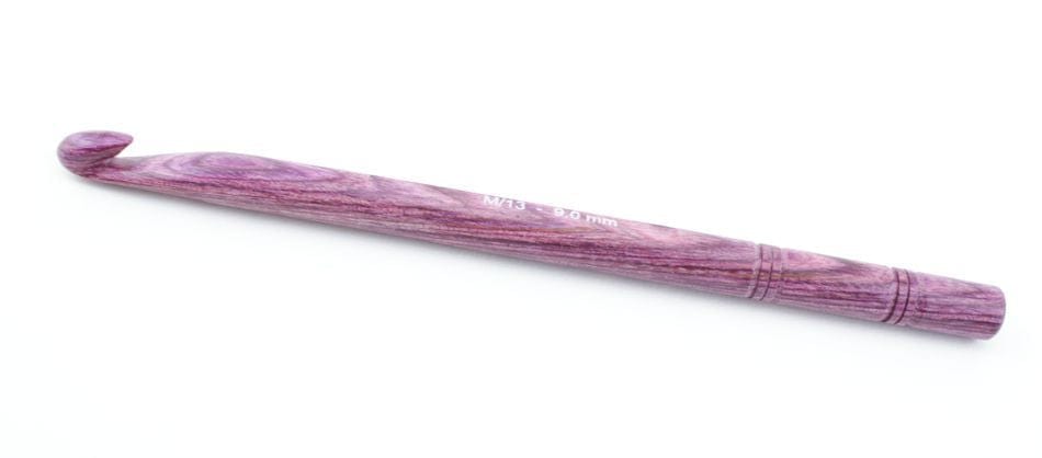 A Knit Pro (Knitters Pride) Dreamz Wooden Crochet Hook by Accessories Unlimited, featuring a smooth, polished purple finish and visible grain, lies on a white background with its size clearly labeled.
