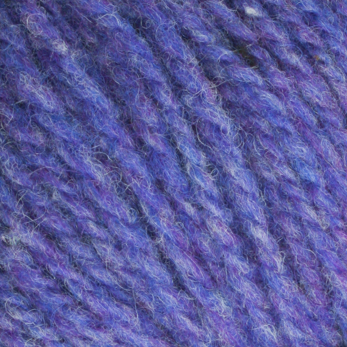 Close-up of Bartlettyarns Maine Wool Yarn (Fisherman 2-Ply) fibers by Bartlettyarns, highlighting the yarn's soft, fuzzy texture and intertwined blue and purple strands.