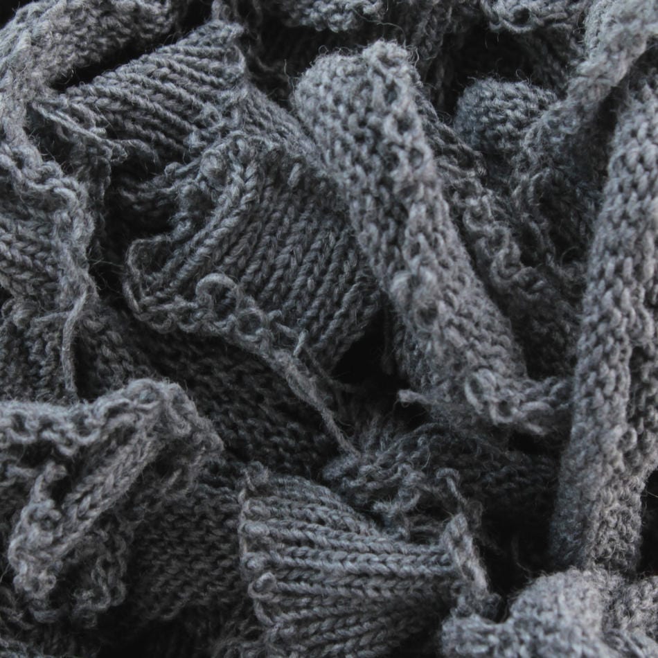 Close-up view of the Harrisville Potholder Loops in a dark gray shade, showcasing the dense, intricate pattern of cotton strands and loops reminiscent of a traditional loom, brought to you by Friendly Loom.