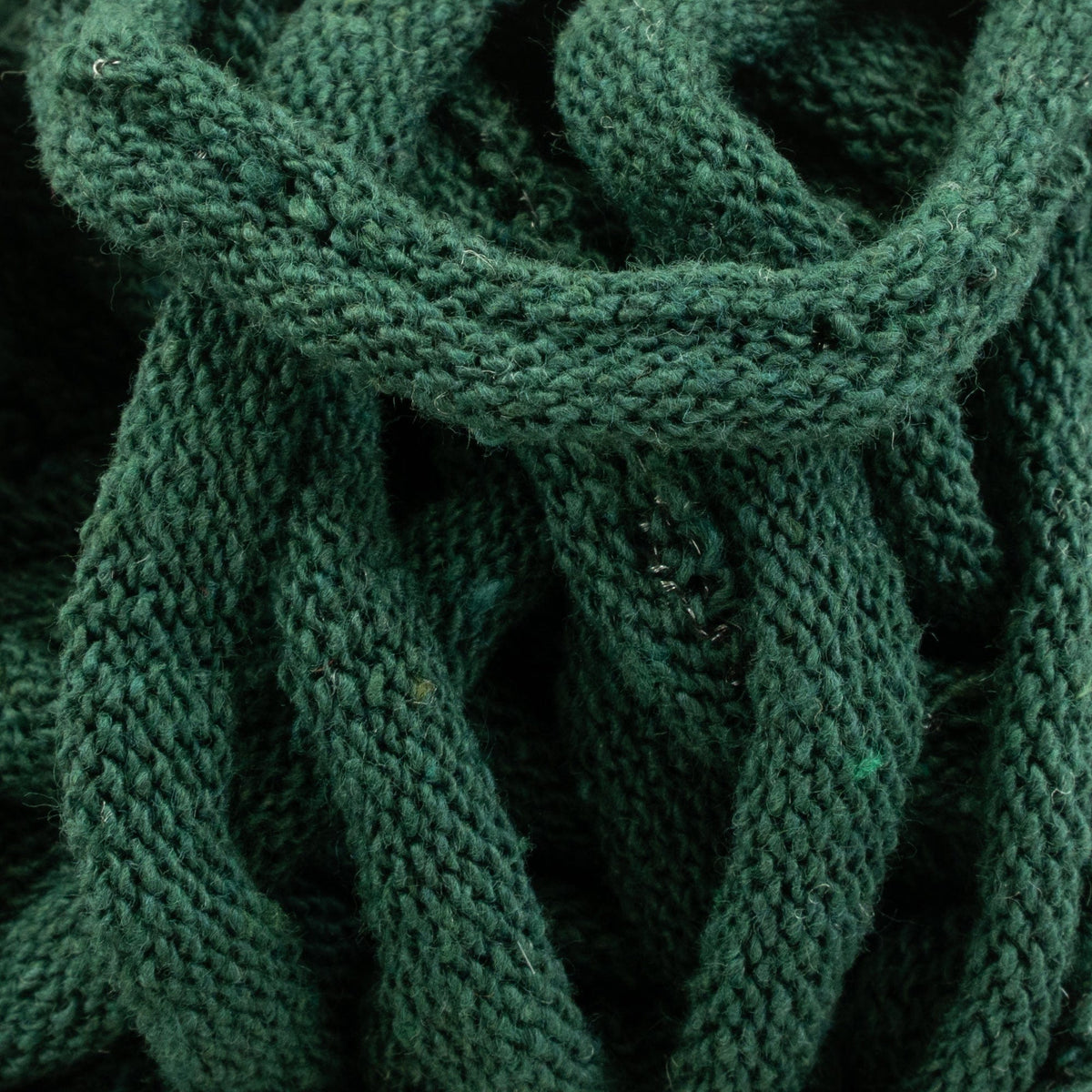 The image showcases a close-up of Harrisville Potholder Loops - Traditional Size by Friendly Loom, featuring a green knitted fabric with an intricate textured, looped pattern crafted from cotton loops. The focus is on the detailed weaving and vibrant green hue, emphasizing the soft, cozy texture reminiscent of a traditional loom design.