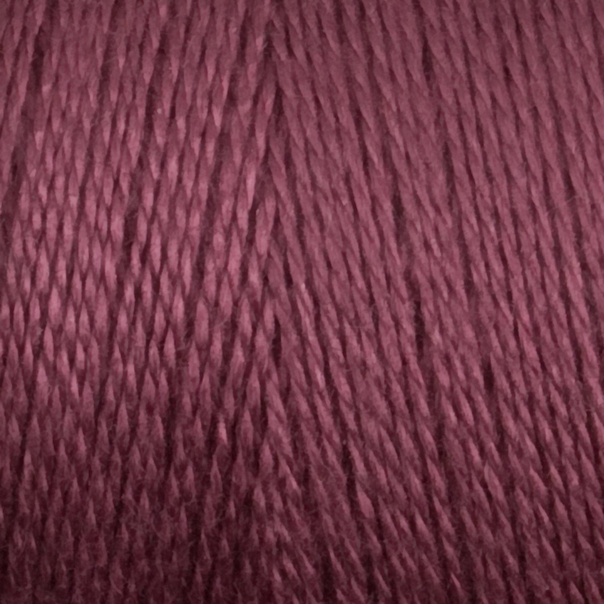 Close-up of Maurice Brassard 8/2 Tencel Yarn | Mini-cone in mauve, tightly wound in parallel strands with a textured, slightly glossy surface—perfect for weaving projects.