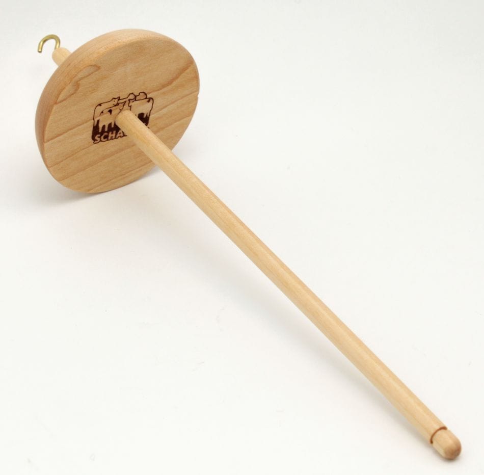 The Schacht Hi-Lo Drop Spindle by Schacht Spindle Co. is a wooden spindle with a round whorl engraved with the Schacht logo, a top hook, and smooth shaft, designed for hand spinning fiber into yarn.
