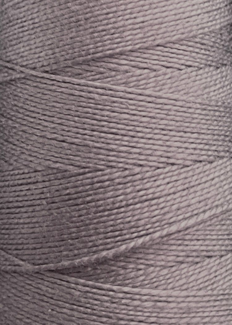 Close-up view of a spool of Circulo 10/2 Looma Mercerized Pearl Cotton Yarn in light gray, highlighting the detailed texture and tightly wound fibers arranged in diagonal layers—ideal as a premium weaving yarn on a large cone and Oeko-Tex certified for quality and safety.