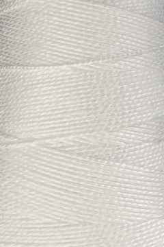 Close-up of a large cone of Circulo 5/2 Looma Mercerized Pearl Cotton Yarn, showcasing its tightly wound, shiny white fibers in vivid detail—crafted from Oeko-Tex certified cotton for lasting quality.