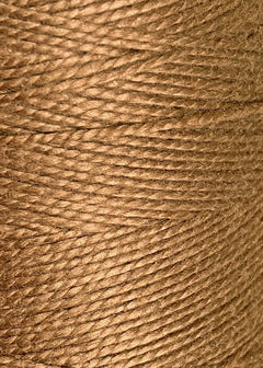 Close-up view of tightly wound, light brown 10/2 Looma Circulo Mercerized Pearl Cotton Yarn on a large cone by Circulo, highlighting the texture and individual strands twisted together in a cylindrical shape.