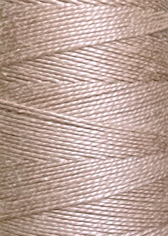 Close-up of Circulo 10/2 Looma Mercerized Pearl Cotton Yarn in beige, wound tightly in even, diagonal layers on a large cone, showcasing the texture and subtle sheen of the high-quality mercerized cotton fibers.