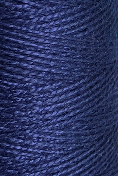 Close-up of Circulo 3/2 Looma Mercerized Pearl Cotton Yarn | Mini Cone in dark blue, tightly wound in even layers to highlight the material’s texture and individual strands.