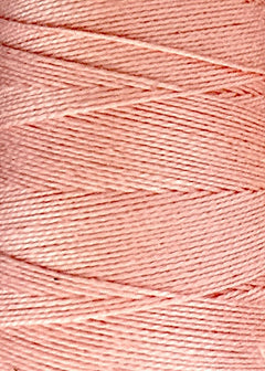 A close-up of light pink 5/2 Looma Circulo Mercerized Pearl Cotton Yarn wound tightly on a mini cone, showcasing its smooth, glossy texture and neatly layered strands from the Circulo brand.