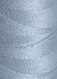 Close-up of a spool of shiny, light blue Circulo 5/2 Looma Mercerized Pearl Cotton Yarn wound tightly in diagonal layers on a large cone, highlighting the texture and sheen of the fibers.