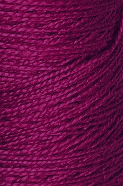 Close-up of a spool of 5/2 Looma Circulo Mercerized Pearl Cotton Yarn | Mini Cone, showcasing its textured magenta hue and twisted fibers in rich, vibrant detail. This Oeko-Tex certified cotton weaving yarn by Circulo ensures both quality and safety for your creative projects.