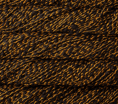 Malabrigo Caracol super bulky merino wool yarn in black with thin, bright orange strands wrapped around it in a thick, textured cross-hatch pattern.