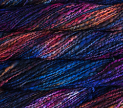 Malabrigo Caracol super bulky merino wool yarn in a variegated blend of dark blue, purple, and orange tones with a handspun look.