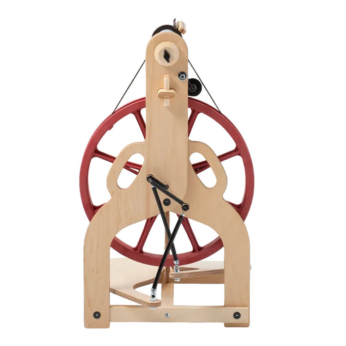 A wooden spinning wheel with a natural light wood frame and a large red wheel, photographed against a solid black background.