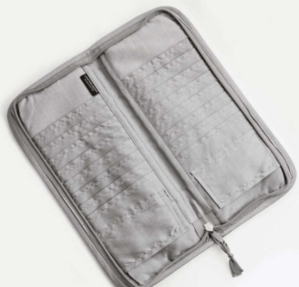 The Lantern Moon Circular Needle Case by Bryson Distributing, Inc. is a light gray IKAT fabric case with a zipper, open to reveal multiple card slots and a small right pocket—ideal for storing needles. It is pictured on a white background.
