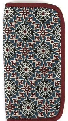 The Lantern Moon DPN Needle Case by Bryson Distributing, Inc. is a rectangular handcrafted case made from IKAT fabric, with a maroon border and geometric floral patterns in maroon, white, and dark green on blue. The wallet stands upright and closed.
