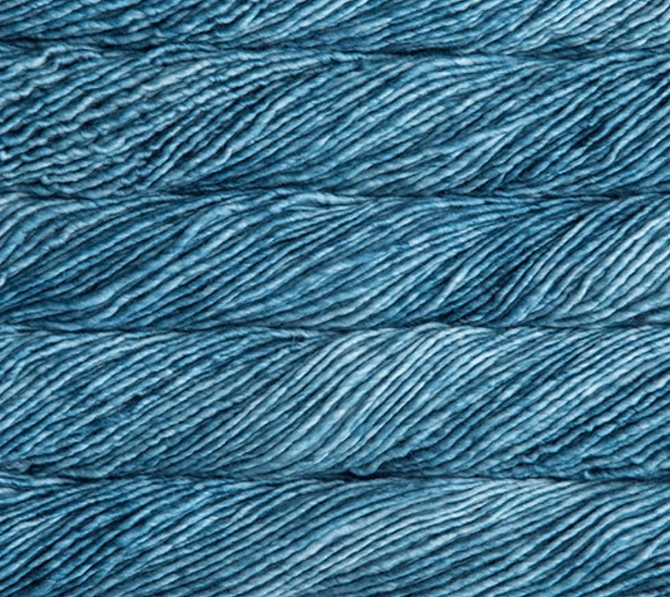Close-up of thick, single-ply Malabrigo Mecha bulky yarn in shades of variegated blue with a soft, heathered texture.
