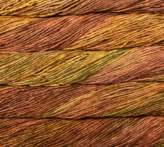 Close-up of stacked skeins of Malabrigo Mecha hand-dyed yarn in variegated shades of olive green, rust, and plum.