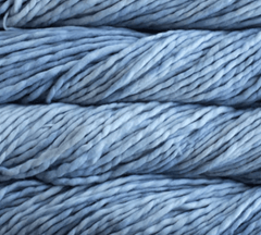 Close-up of three stacked skeins of thick, light blue, single-ply Malabrigo Rasta super bulky yarn.