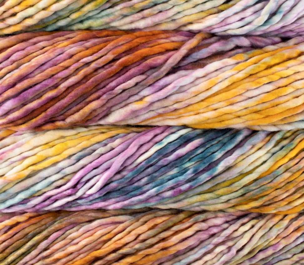 Close-up of thick, multicolored Malabrigo Rasta yarn in variegated shades of purple, orange, yellow, and blue.