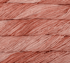 Close-up of four stacked hanks of dusty-rose Malabrigo Rios yarn.
