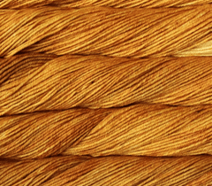 Close-up view of golden-yellow Malabrigo Rios kettle-dyed yarn twisted into skeins.