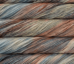 Stacked skeins of Malabrigo Rios yarn in variegated, muted shades of blue, green, and copper.