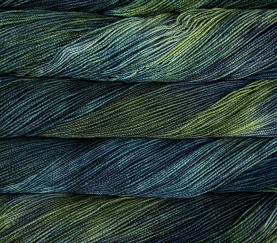 A skein of Malabrigo Sock fingering weight yarn in variegated tones of dark green, teal, and charcoal.