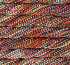 Close-up of Malabrigo Torzal sport weight yarn featuring a multi-ply, variegated blend of orange, teal, purple, and cream fibers twisted together.